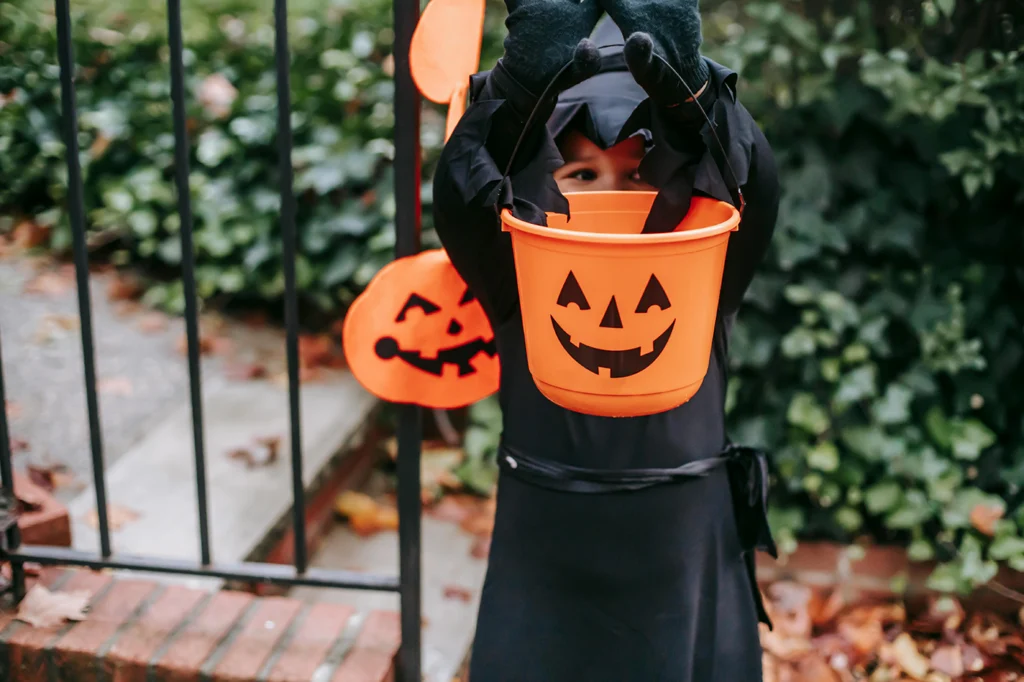 Kid trick or treating for Halloween and enjoying non candy treats